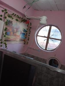 a round window in a room with a pink wall at Pousada Lua Nua in Niterói