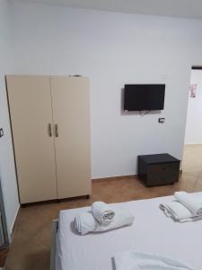 a bedroom with a bed and a tv and a cabinet at Star Room's in Vlorë