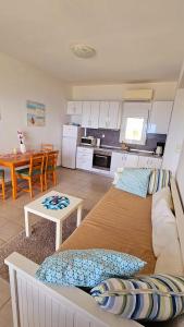 a living room with a bed and a kitchen at Syvota Sunset Apartments in Perdika
