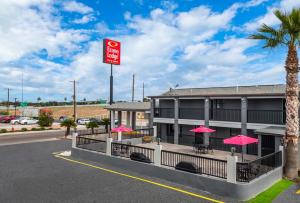 un hôtel avec des parasols roses en face d'un bâtiment dans l'établissement Econo Lodge Inn & Suites, à Laredo