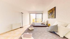 uma sala de estar com uma cama e um sofá em Marina vue mer em Le Grau-du-Roi