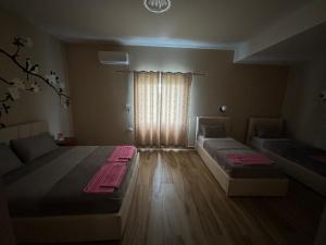 a living room with two beds and a window at Hanna & Solei Hotel in Berat