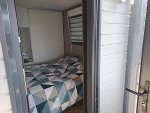 a small bedroom with a bed in a closet at Chalet contemporain in Carnac