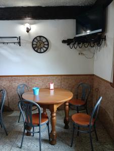 a table with chairs and a clock on the wall at hotel santa Maria do Poio in Lugo