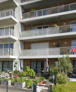 an apartment building with balconies and plants in front of it at Havre de paix in Coulaines