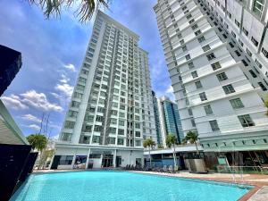 a pool in front of two tall buildings at 9am-5pm, SAME DAY CHECK IN AND CHECK OUT, Work From Home, Shaftsbury-Cyberjaya, Comfy Home by Flexihome-MY in Cyberjaya