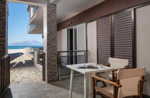 uma varanda com mesa e cadeiras e vista para a praia em house giota em Sarti