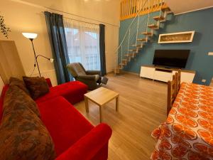 uma sala de estar com um sofá vermelho e uma televisão em K&K Puck em Puck