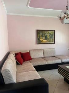 sala de estar con sofá y 2 almohadas rojas en Nicole's Cozy Apartment, en Berat