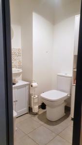 a white bathroom with a toilet and a sink at Un petit cocon au pied du Stade de France in Saint-Denis