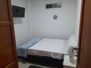 een slaapkamer met een bed in een witte kamer bij Apartamento Hermoso Riosucio 201 in Ruiosucio