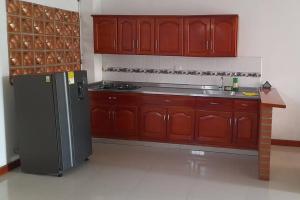 een keuken met houten kasten en een koelkast bij Apartamento Hermoso Riosucio 201 in Ruiosucio