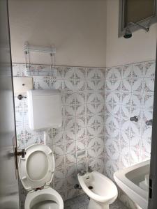 łazienka z toaletą, umywalką i wanną w obiekcie HOTEL ROSSINI w Rimini