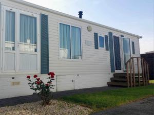 Casa blanca con persianas azules y escalera en cottage Tangro, en Middelkerke