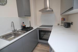 a small kitchen with a sink and a stove at Emerald nest Eastbourne in Eastbourne