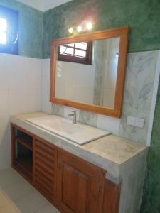 a bathroom with a sink and a mirror at Beach House Habaraduwa in Koggala