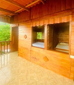 Cabaña de madera con cama en su interior en Cabaña Monarca en Turrialba