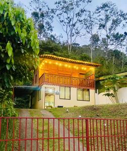 una casa con una valla delante de ella en Cabaña Monarca, en Turrialba