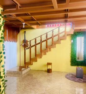 a staircase in a room with a yellow wall at Cabaña Monarca in Turrialba