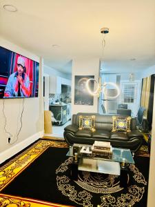 uma sala de estar com um sofá preto e uma televisão em Newly renovated first floor apartment getaway em Springfield