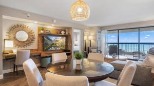 a living room with a table and chairs and a couch at Luxury Oceanfront 2 Bedroom Apartment at Waikiki Beach Tower in Honolulu