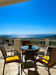 een patio met een tafel en stoelen en de oceaan bij Villa ELLA in Bar