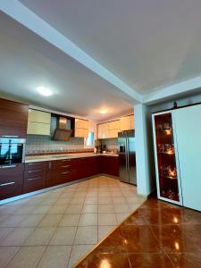 a large kitchen with brown cabinets and a refrigerator at Villa ELLA in Bar