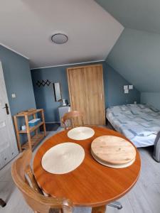 een kamer met een houten tafel en een bed bij Mickiewiczówka in Mikoszewo