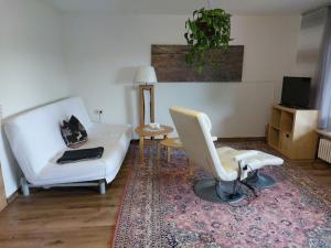 a living room with a white couch and a chair at Hibiskus - a83456 in Leutkirch im Allgäu