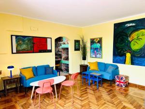 salon z niebieskimi kanapami, stołem i krzesłami w obiekcie HOSTEL ART & JOY w Puli