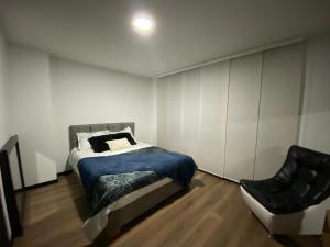 Sibundoy的住宿－Apartamento 501 Edificio Habitar Castelvi，一间卧室配有一张床和一把椅子