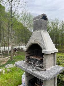 a stone oven in a park with a person in the background at Noveli Tiny House in Ardeşen