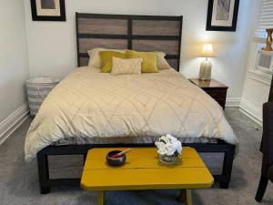 a bedroom with a large bed with a yellow table at Elegant Private Room in Oakland, Pittsburgh. in Pittsburgh