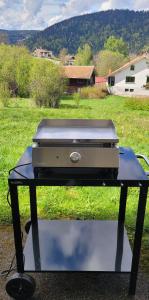 a grill sitting on a table in a field at Le Petit Sapin in Xonrupt-Longemer