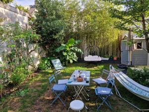um quintal com uma rede de descanso, uma mesa e cadeiras em Maison, 4 chambres, métro, climatisation em Villejuif