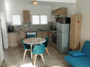 a kitchen with a table and chairs and a blue couch at Le Gîte de Pandore in Arles