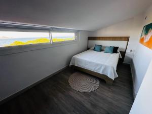 Habitación pequeña con cama y ventana en Salles Beach Duplex Apartamento 45 en L'Estartit