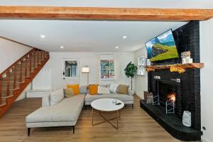 Una sala de estar con un sofá y una chimenea. en 157 - Angelenos Cabin - Meredith Lodging, en Big Bear City