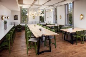 Hotel Ursa في Orono: مطعم بطاولات خشبية وكراسي خضراء