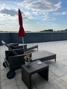 a patio with two tables and an umbrella on a roof at Hotel Apart in Warsaw