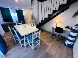 un comedor con mesa y sillas y una escalera en Salles Beach Duplex Apartamento 45, en L'Estartit