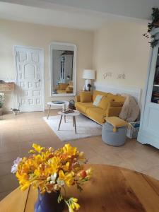 a living room with a yellow couch and a table at Maison JUAN LES PINS Plages clim charme in Antibes