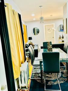 - une salle à manger avec une table, des chaises et des rideaux jaunes dans l'établissement Newly renovated first floor apartment getaway, à Springfield