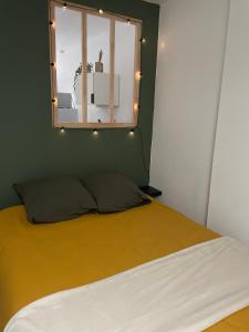 een slaapkamer met een bed met een raam en verlichting bij BERCK sur Mer Appartement Cosy à 50 métres de la plage in Berck-sur-Mer