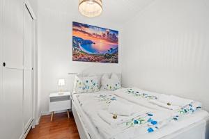 腓特烈港的住宿－Fewo am See，白色卧室配有一张床,墙上挂着一幅画