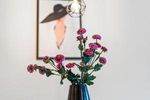 腓特烈港的住宿－Fewo am See，一张带紫色花的花瓶,放在一个照片的房间