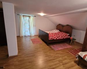 1 dormitorio con 1 cama y suelo de madera en Landhaus Kate en Lusnić