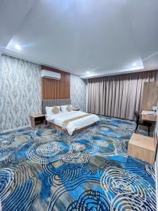 a large room with a bed and a large carpet at شقق بيت المدينة للشقق المخدومة in Qabāʼ