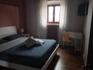 a bedroom with a bed and a desk and a window at Il Podere di Massi in Barberino di Mugello