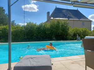 a boy laying in a swimming pool with a frisbee at Chateau de Brie in Aulnay